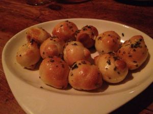 Warm bread knots with rosemary, olive oil, garlic, and sea salt.