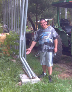 Marco pointing at the little nick in the barn he made with the tractor