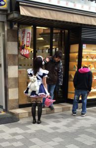 A maid rustles up a customer for the cafe.