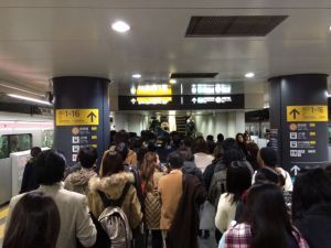The crowd funnels its way up the sole UP escalator on a subway platform in Shibuya station.