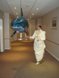 A lady takes her remote-controlled flying inflatable shark for a stroll