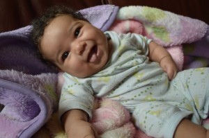 A little girl in blue learning how to smile at you!