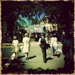 Extras in period costume cross the street for Unbroken 