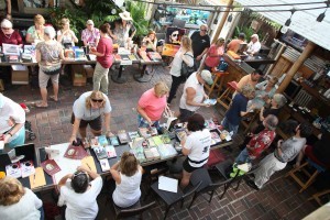 Authors lined up on both side of the patio at the saloon.