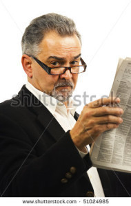 stock-photo-an-older-businessman-with-glasses-holds-up-a-newspaper-51024985