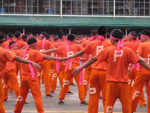 Inmate dancers wearing pink ribbons to indicate cancer fundraising efforts. <br />Yes, the prison is raising funds for cancer research.