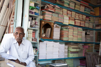 Senior Indian man sitting is his bookshop