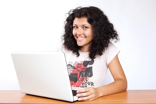 Smiling author at laptop, courtesy of CollegeDegrees360.