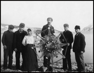 A group of people hold a Russian Christmas star on a beach in Unalaska in the early 1900s.