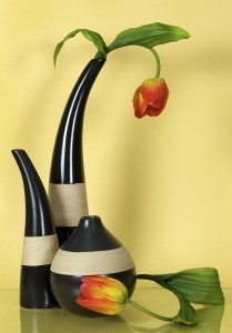 Three striped ceramic vases with flowers on yellow