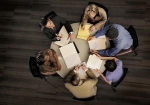 group of confident professional employees in a serious meeting from above