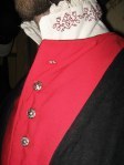 Close-up of the buttons, neckline, and embroidered shirt.