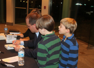 Signing books while my sons Jimmy and Bobby look on. 