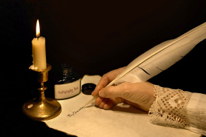 Hand writing a letter with a goose feather