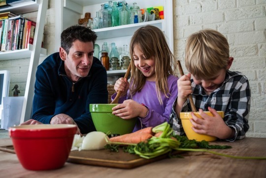 Christopher Freeman and his children cooking together. 