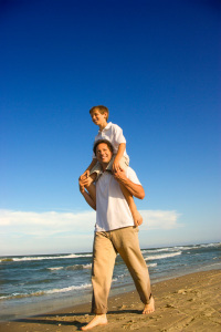 Dad carrying son on his shoulders.