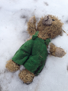 Sad teddy bear in adorable overalls