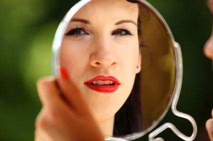 Young woman looking at mirror