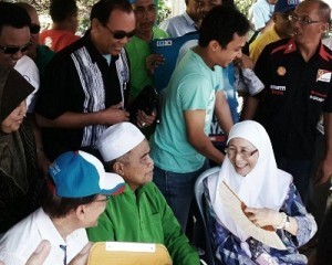 Anwar (paling kiri) mengiringi Wan Azizah bersama pengundi di pusat pengundian Sek Keb Saujana Impian.