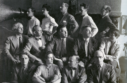 “Group photograph of ‘Artists in Exile.’” In Peggy Guggenheim’s New York apartment, 1942. Front Row: Stanley William Hayter, Leonara Carrington, Frederick Kiesler, Kurt Seligmann. Second Row: Max Ernst, Amedee Ozenfant, Andre Breton, Fernand Leger, Berenice Abbott. Third Row: Jimmy Ernst, Peggy Guggenheim, John Ferren, Marcel Duchamp, Piet Mondrian. Via http://www.danshamptons.com/content/hamptonstyle/2008/aug_29/historic.html