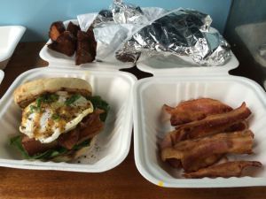 Clockwise from left: 1) Organic pork belly confit and free-range egg sandwich with spinach, yolks, and honey dijon, 2) truffle potato skewers, 3) extra bacon.