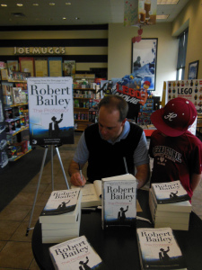 Signing a book while my son Jimmy looks on