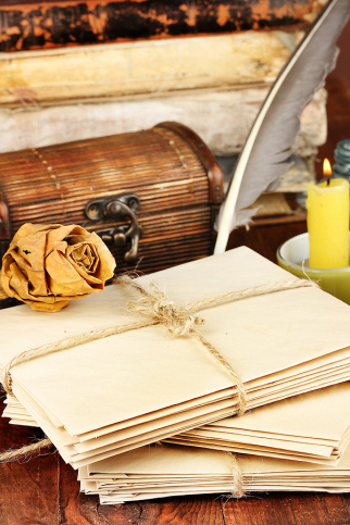 Stack of old letters with ink quill and feather pen