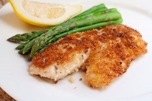 Fried breaded fish with asparagus and lemon