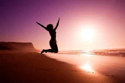 Woman in silouette jumping on beach