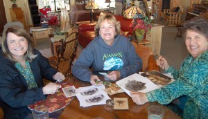 Alice's granddaughters Marilyn and Chris enjoying old family photos with Barb.