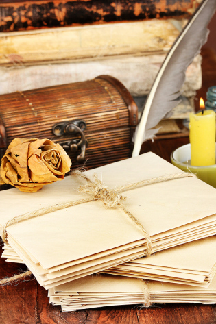 Stack of old letters with ink quill and feather pen