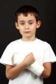9992047-boy-with-broken-hand-in-cast-over-black