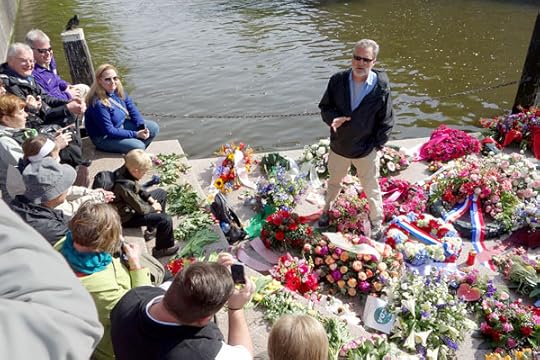 We were in Amsterdam on the Dutch Memorial Day. Throughout Europe, various monuments remind people of the challenges societies have as dense and diverse populations struggle to live peacefully together. Amsterdam’s monument to the homosexual victims of the Holocaust was covered in flowers, providing a fine lectern for our guide, Reid, to give us some historical context.