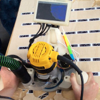 Hand-held, the router path is kept on track with XY adjustments.