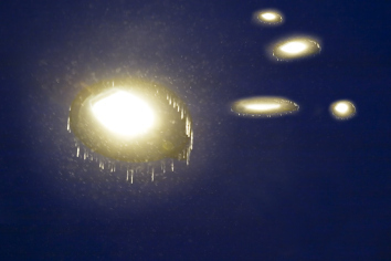 A dark night sky with several glowing discs of light