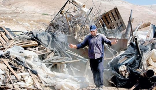 A Palestinian man inspecting the remains of his tent