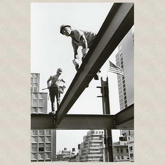Steelworkers perch precariously on steel beams in a construction site