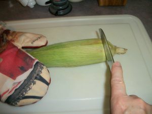 Slice off husks at beginning of corn cob.