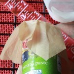 Shape parchment squares around tomato paste can