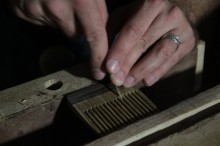 Brian Timmons putting final details on a wooden beard comb