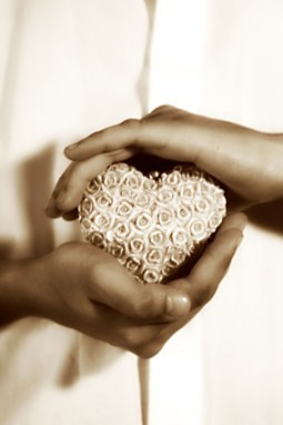 hands holding a heart-shaped stone