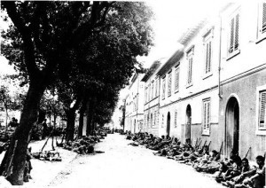 Japanese-American troops of 100th Infantry Battalion of US 442nd Regimental Combat Team resting on the side of a street in Livorno, Italy, 19 Jul 1944. (Hawaii War Records Depository)