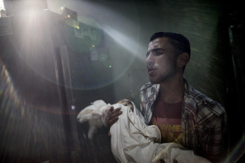 A relative of two-year old Lamar Radiya holds her body at the morgue of the Kamal Adwan hospital in Beit Lahia: photo by Marco Longari / AFP,, 24 July 2014