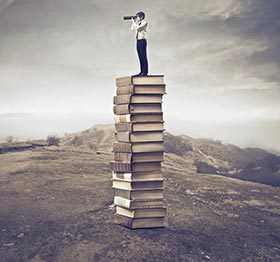 Find Bestselling Book Ideas - Man on a Stack of Books
