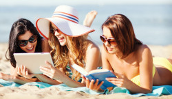 girls with tablet pc on the beach