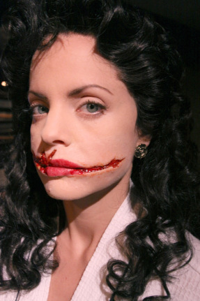 Mena Suvari personificada como el fantasma de Elizabeth Short, con la marca de los cortes en la cara de la víctima real.
