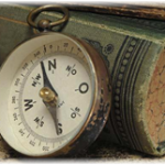 Explorer's compass leaning on a book