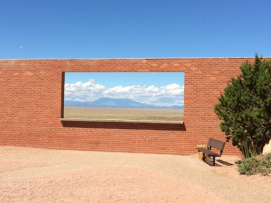 It's not a painting; it's an open space in the wall, overlooking Arizona's desert. Beyond is the Bar-T-Bar ranch, with the San Francisco mountain range in the background. 
