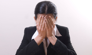 Business woman crying head in hands