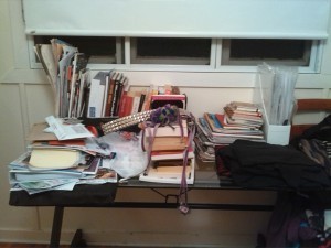desk completely covered with books and papers